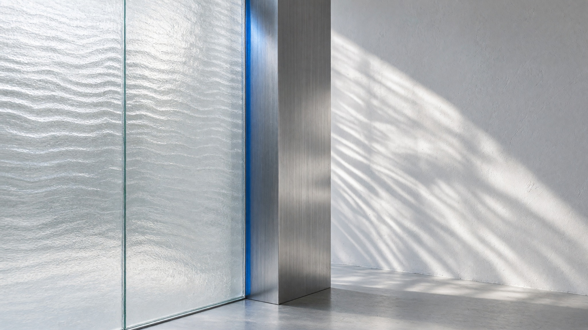 Daylight refracting through frosted glass onto pale surfaces and brushed metal.